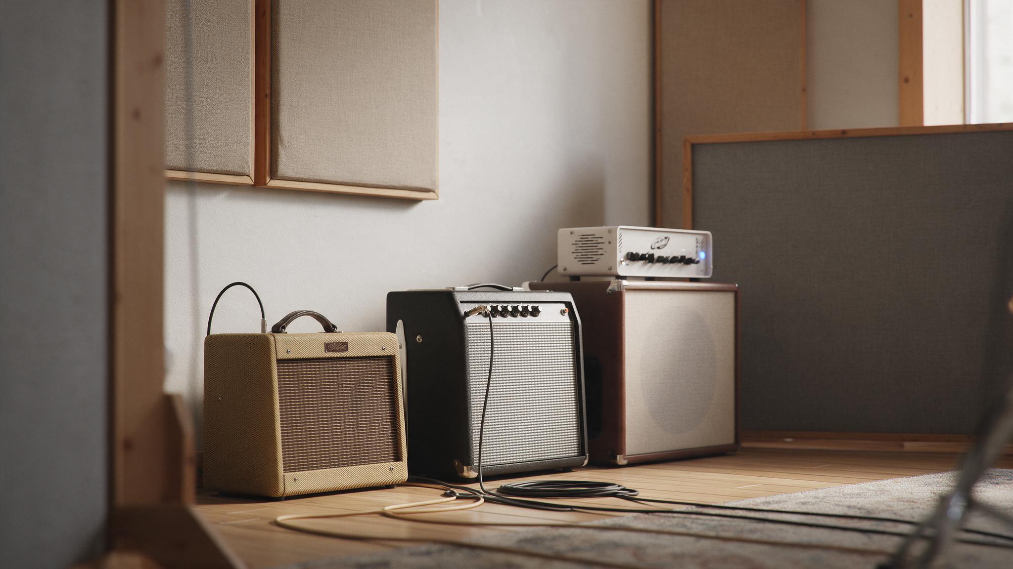 Salle de répétition avec combos guitare à lampes et petite tête d'ampli basse blanche sur baffle